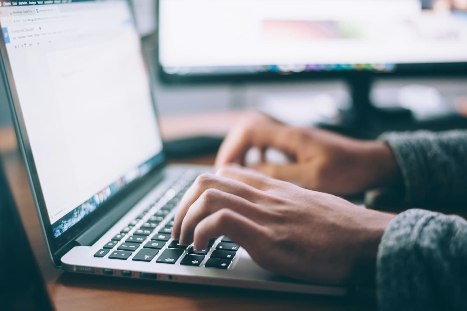 Hands typing a document on a laptop