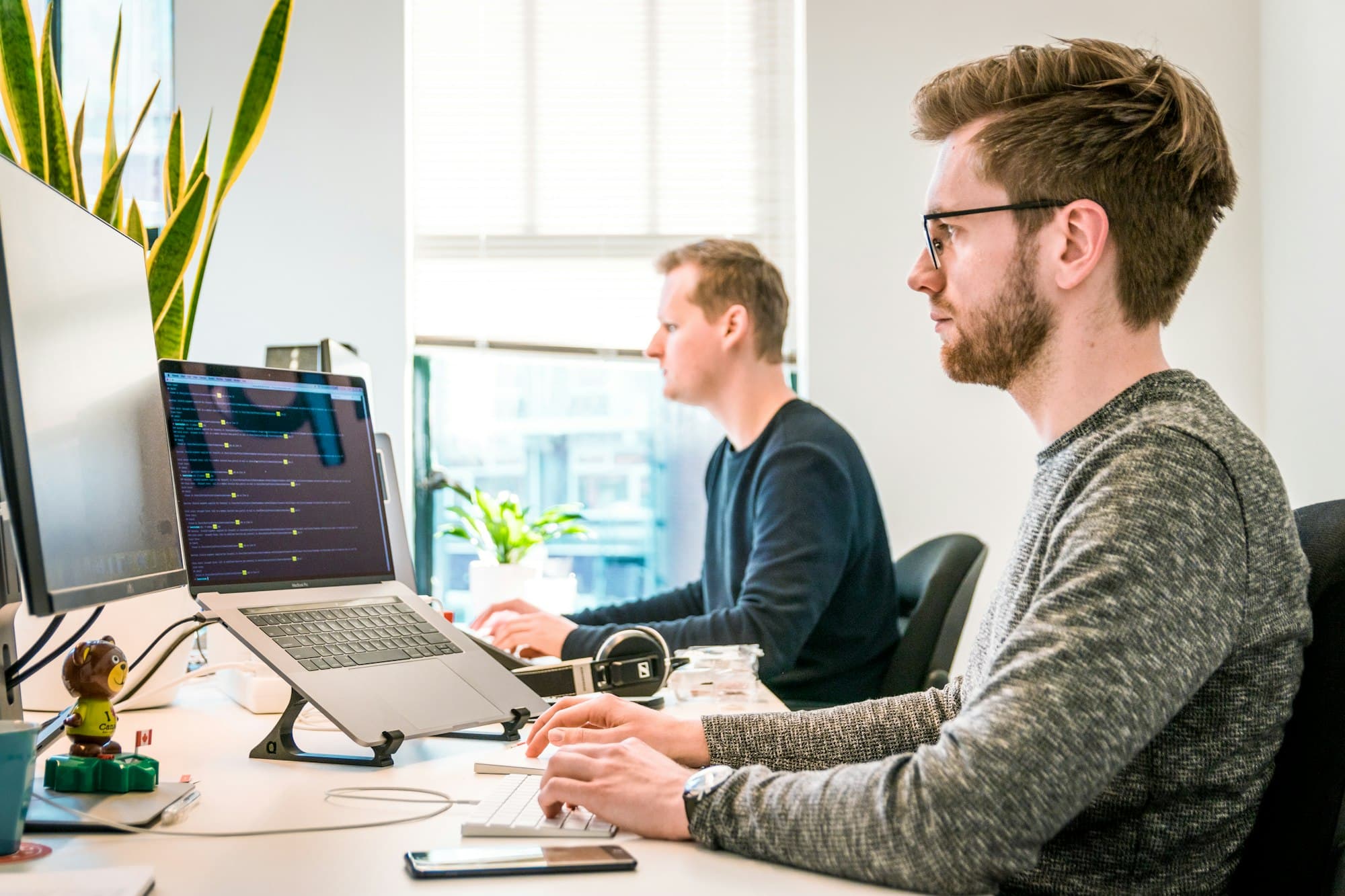 Two colleagues working at their computers in a bright office